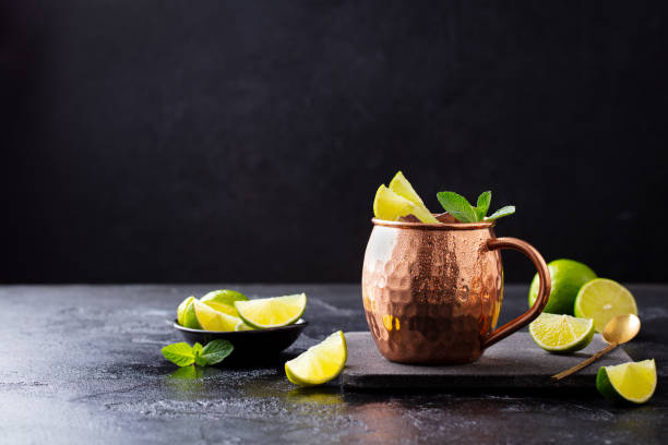 istock Cold Moscow Mules cocktail with ginger beer, vodka, lime and mint. Grey stone background. Copy space. 1205733491