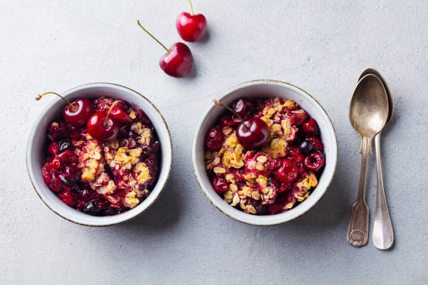 istock Cherry, red berry crumble in bowl. Grey stone background. Top view. 1205733590