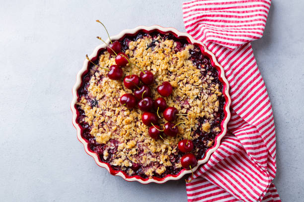 istock Cherry, red berry crumble in baking dish. Grey stone background. Top view. 1205733951