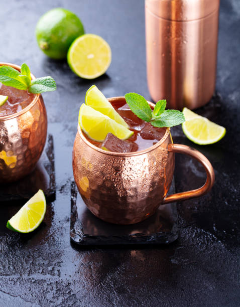 istock Cold Moscow Mules cocktail with ginger beer, vodka, lime and mint. Grey stone background. 1205734690