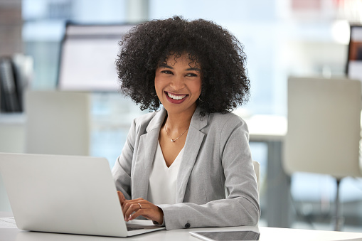 Portrait of an attractive young businesswoman working on a laptop inside her office