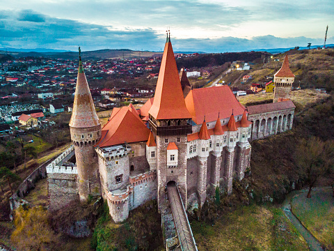 Hunedoara, Romania - 12 February, 2020: drone shot depicting an aerial view of Corvin Castle (Hunyadi Castle) at sunrise in Hunedoara, a city in the Transylvania region of Romania. The castle is a Gothic-Renaissance castle. It is one of the largest castles in Europe and figures in a list of the Seven Wonders of Romania.