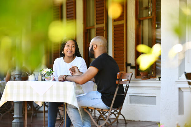 Selective focus Young African couple sitting on a porch having breakfast together