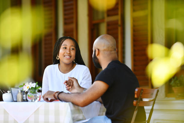 istock Young African couple sitting on a veranda holding hands 1205737143