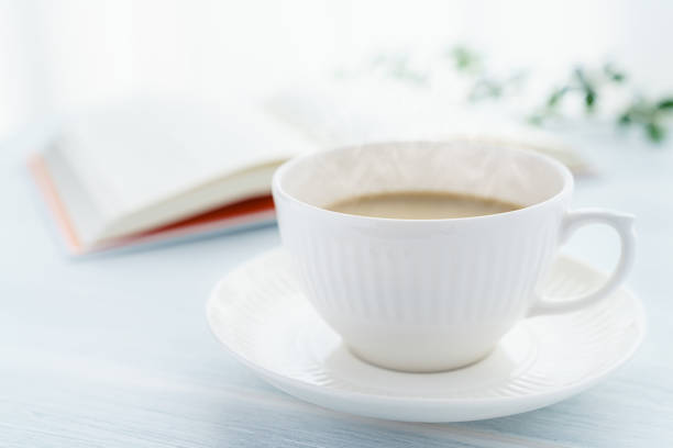 istock Cup of tea with milk and book on wooden table 1205737340