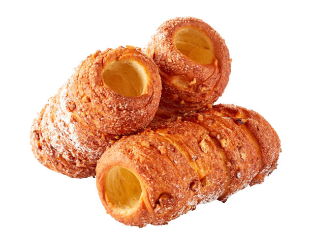 Hungarian chimney cake or kurtos kalacs - sweet rolled dessert Three chimney cakes czech street food : rolled dough wrapped around a stick sprinkled with cinnamon and nuts isolated on white, close-up trdelník stock pictures, royalty-free photos & images