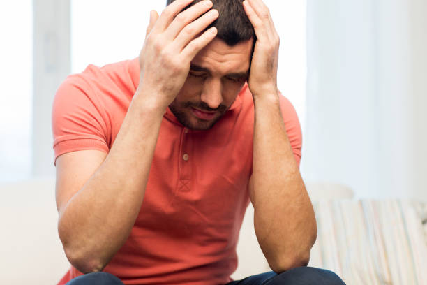 istock unhappy man suffering from head ache at home 1205739508