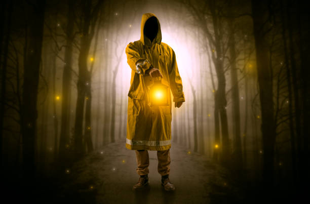 таинственный человек, и исходит от пути в лесу со светящимся фонарем концепции - bootes стоковые фото и изображения