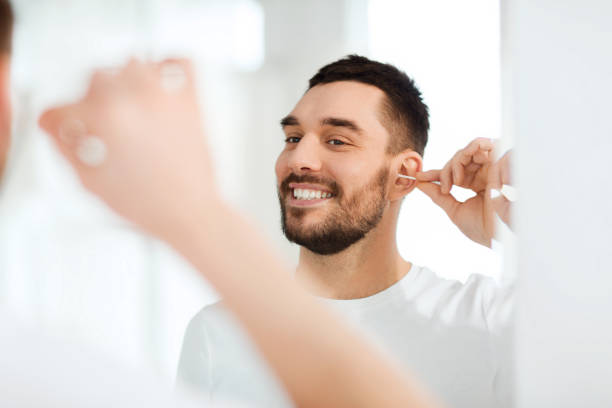istock man cleaning ear with cotton swab at bathroom 1205739840