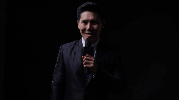 istock Male newscaster is reporting unusual circumstances and reporting economic news with isolate black background. 1205740072