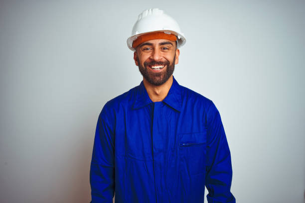 istock Handsome indian worker man wearing uniform and helmet over isolated white background with a happy and cool smile on face. Lucky person. 1205740942