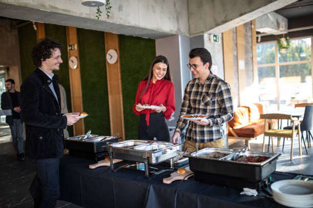 istock Beautiful business people serving themselves at buffet after work 1205741261