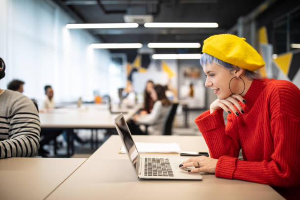 istock Beautiful woman using laptop at open space workplace 1205741301
