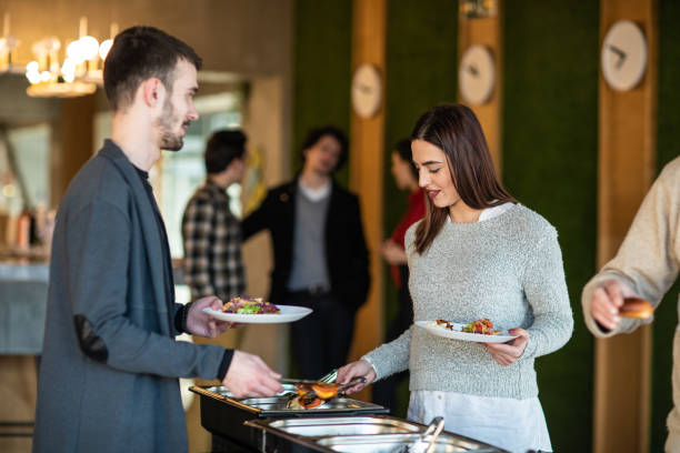 istock Happy business people serving themselves at buffet 1205741421