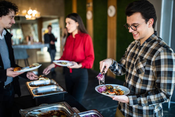 istock Beautiful business people serving themselves at buffet after work 1205741446