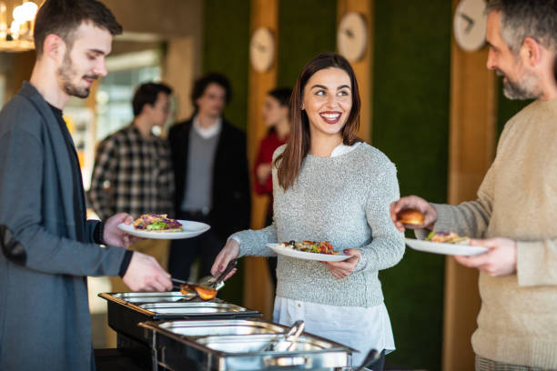 istock Business people talking and taking food at buffet after work 1205741725