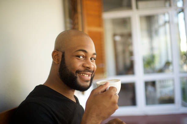 istock Millennial man having coffee on a porch relaxing smiling looking at camera 1205742692