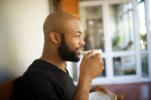 istock Millennial man having coffee on a porch looking out 1205742696