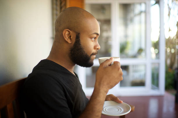 istock Millennial man drinking coffee on a porch pondering 1205742722