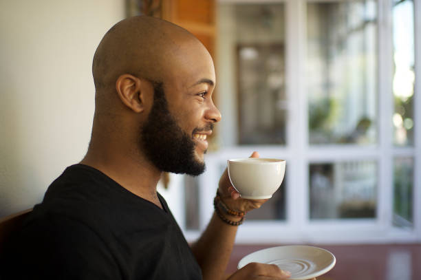 istock Millennial man having coffee on a porch relaxing and laughing 1205742756
