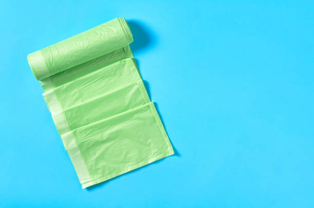 istock One green disposable plastic garbage bag on blue background. Copy space. Top view 1205743261