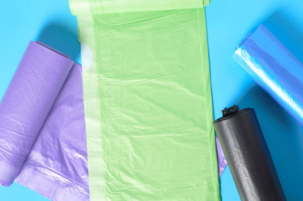 istock Scattered rolls of disposable plastic garbage bag on blue background. Top view. Close-up 1205743312