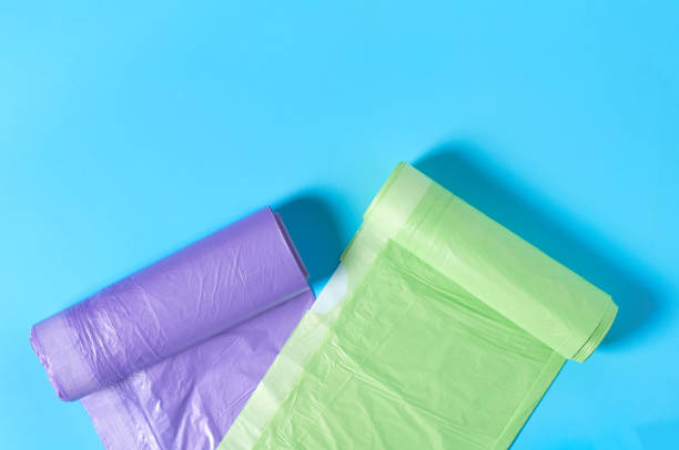 istock Scattered rolls of disposable plastic garbage bag on blue background. Copy space. Top view 1205743317