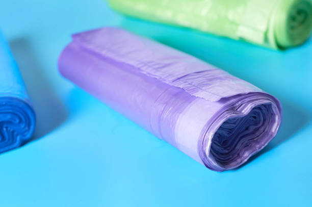 istock Scattered rolls of disposable plastic garbage bag on blue background. Close-up 1205743348