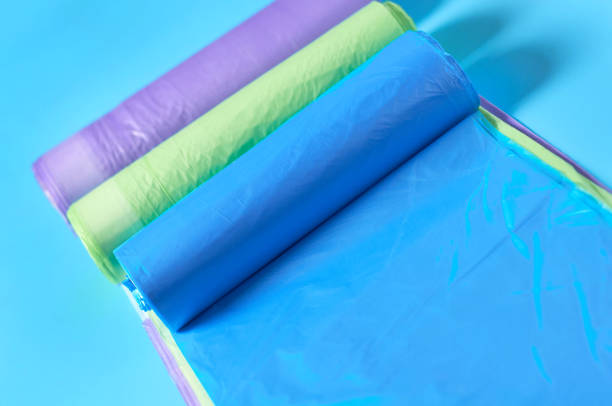istock Row of rolls of disposable plastic garbage bag on blue background. Close-up 1205743385