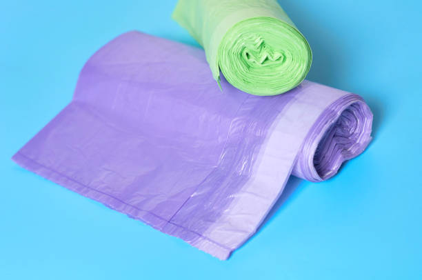 istock Two roll of disposable plastic garbage bag on blue background. Close-up 1205743411