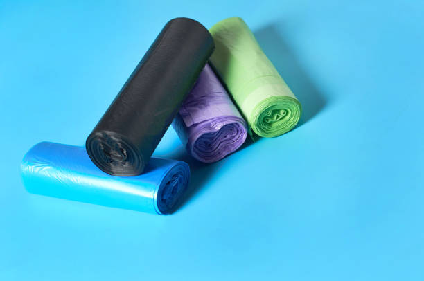 istock Heap of rolls of disposable plastic garbage bag on blue background. Copy space 1205743419
