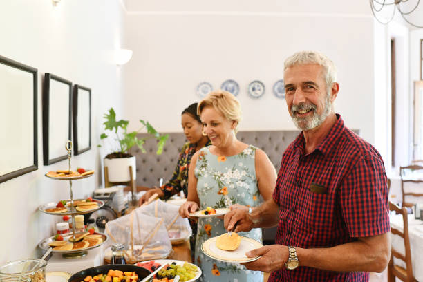 istock Guests Dishing up a la Carte buffet breakfast smiling at the camera 1205743581