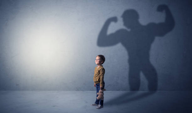 istock Muscleman shadow behind waggish little boy 1205743684