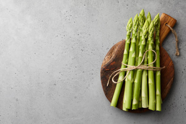 istock Bunch of green asparagus on concrete background 1205744735