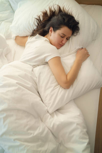 istock Young beautiful alone woman sleeping on bed in bedroom 1205747114