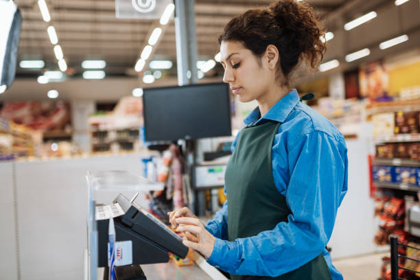 weibliche latina-mitarbeiterin im supermarkt - supermarket sales clerk retail cashier stock-fotos und bilder