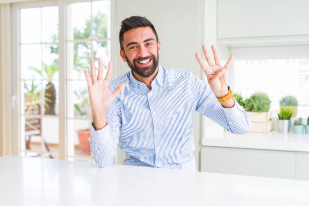 istock Handsome hispanic business man showing and pointing up with fingers number nine while smiling confident and happy. 1205748857