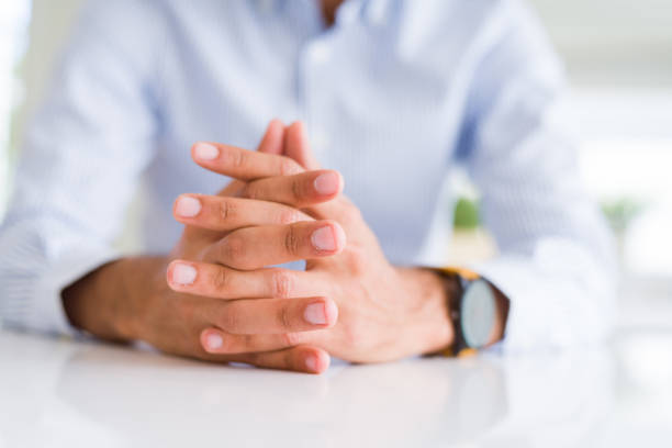istock Close up of man with crossed hands over white table 1205749083