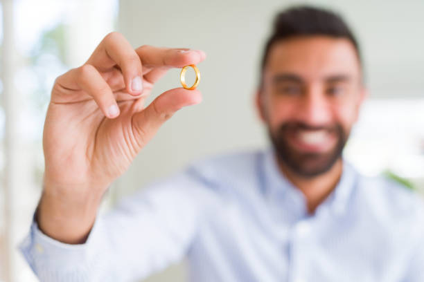 istock Handsome man smiling and showing wedding alliance ring 1205749100