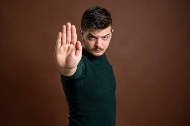 istock Man with brown hair showing stop 1205750444
