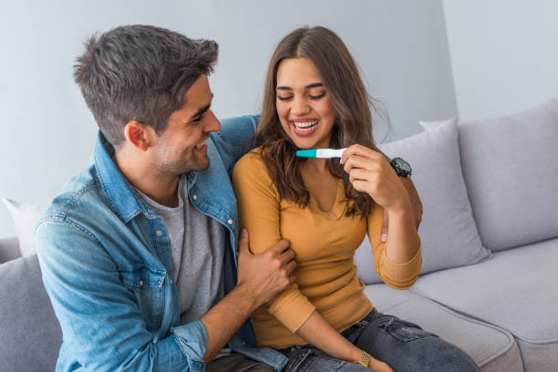 istock Woman surprising her husband with positive pregnancy test 1205750553