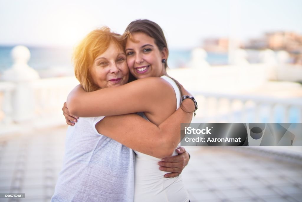 Beautiful mother and daugther hugging at terrace with happy face Mother Stock Photo