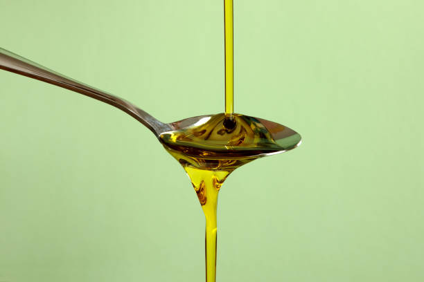 оливковое масло льется вниз, показывая вязкость и гравитацию - oil olive стоковые фото и изображения