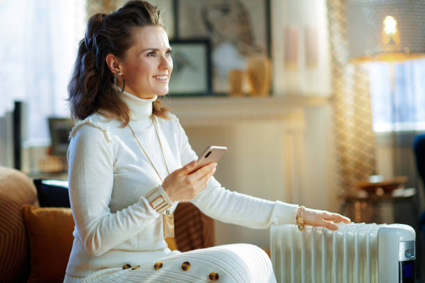 istock woman near radiator using smartphone app for temperature control 1205755089