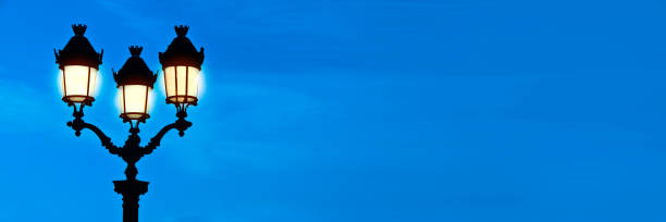 istock Illuminated lamppost at night, blue sky panoramic background in Paris, France 1205755694