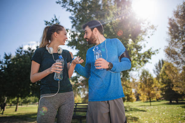 istock Tired athletes taking a break to rehydrate after jogging 1205758600