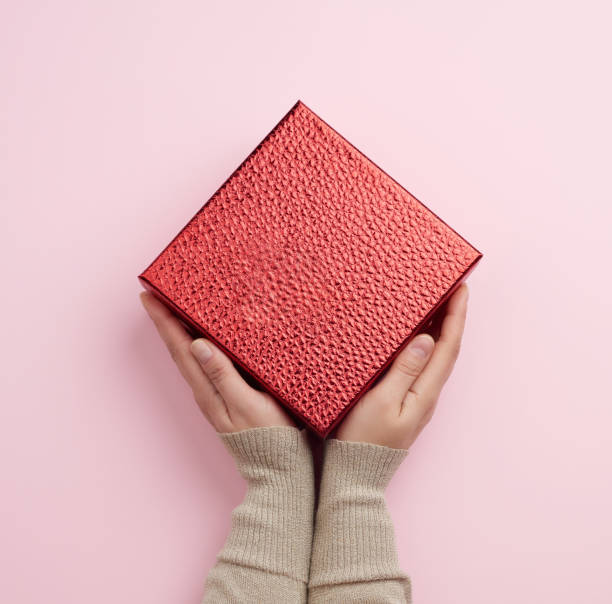 istock female hand holds a red box, concept of congratulations 1205761873