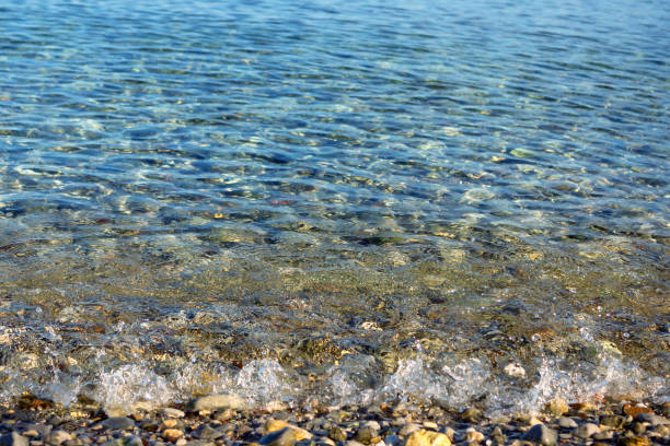 istock Waves with foam blue  sea on a sunny sandy beach in resort on summer vacation rest. 1205762278