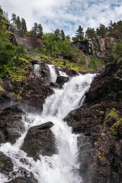 Waterfall falling down mountains Big waterfall flows through the wilderness in the mountains 3610 stock pictures, royalty-free photos & images