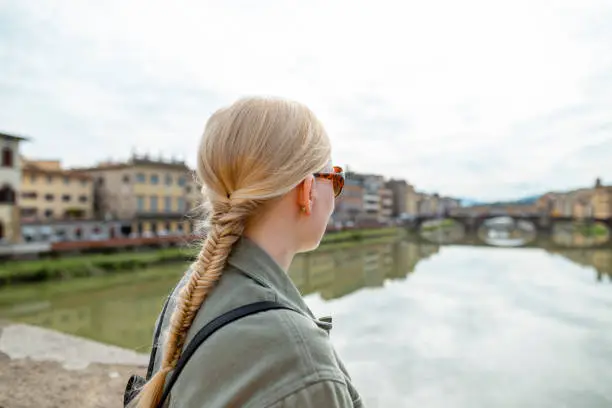 Woman travelling in Florence. She is looking away from the camera wearing sunglasses.